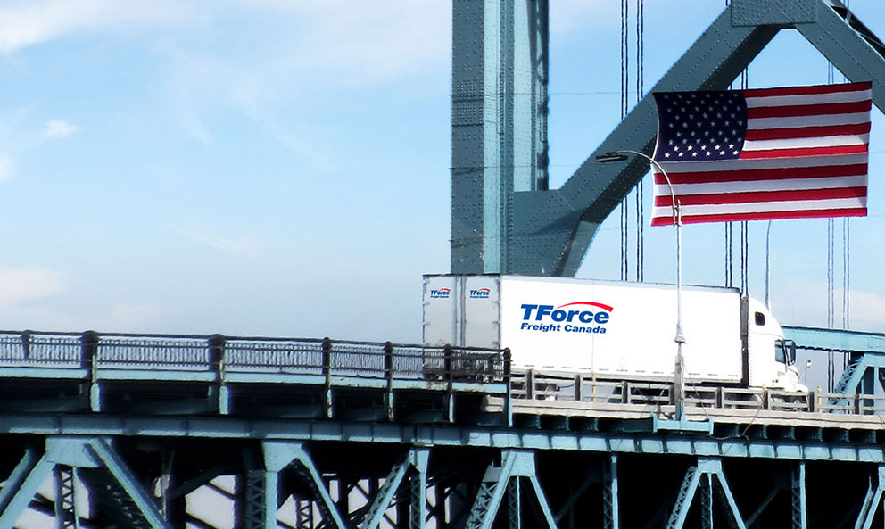 Semi-remorque TForce Freight Canada roulant vers les États-Unis à partir du Canada transportant un chargement partiel